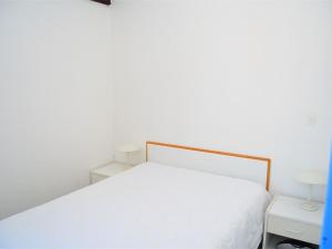 een wit bed in een witte kamer met 2 lampen bij Appartement Port Barcarès, 3 pièces, 5 personnes - FR-1-431-24 in Le Barcarès