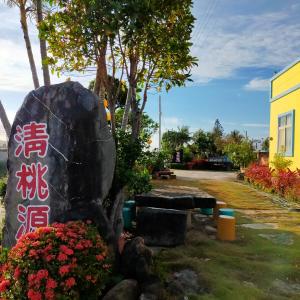 a rock with writing on it next to flowers at Qing Taoyuan Homestay in Hengchun South Gate