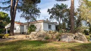 a white house with trees in front of it at Chalet con piscina en Torrelodones in Torrelodones