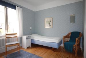 a small bedroom with a bed and a chair at Vadstena Folkhögskola Vandrarhem in Vadstena