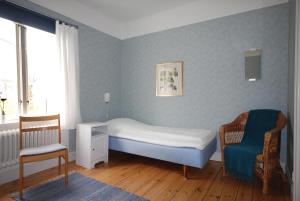 ヴァステーナにあるVadstena Folkhögskola Vandrarhemの小さなベッドルーム(ベッド1台、椅子付)