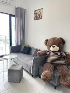 ein großer Teddybär auf einem Stuhl im Wohnzimmer in der Unterkunft HomeFeel Netflix Youtube WiFi 5min drive to DesaPark in Kuala Lumpur