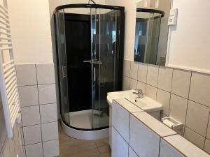 La salle de bains est pourvue d'une douche et d'un lavabo. dans l'établissement Lumineux appartements à 100m plage, à Berck-sur-Mer