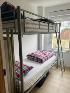 Ce dortoir comprend 2 lits superposés et une fenêtre. dans l'établissement Lumineux appartements à 100m plage, à Berck-sur-Mer