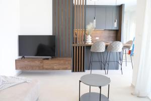 a living room with a tv and a table with stools at Brand new apartment with private pool in Njivice