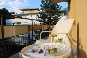 una mesa con una revista y un bol de cristal en el balcón en Elina Apartment, en Merano