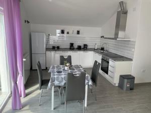 a kitchen with a table and chairs in a room at Studio Apartman Rubinić in Lovran