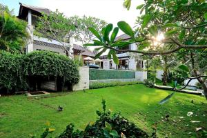 un patio frente a una casa con césped verde en Lumi Villa en Uluwatu