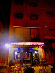 a restaurant with tables and chairs in front of a building at Pensión Juan Pedro in Roquetas de Mar