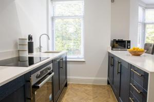 a kitchen with blue cabinets and a counter top at Designer Cardiff Apartments in Cardiff