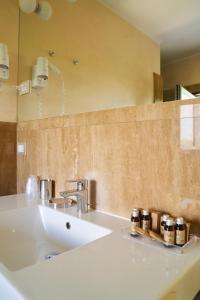 ein Badezimmer mit einem weißen Waschbecken und einem Spiegel in der Unterkunft Aparthotel La Pineta in Lido di Jesolo