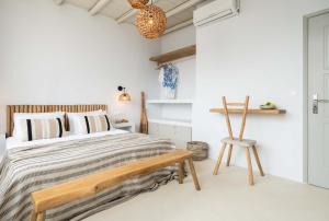 a bedroom with a bed and a wooden chair at Cavos Paros Boho Chic sea-view apartment in Aliki in Aliki