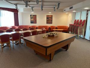 a waiting room with tables and chairs in a room at Hotel Estella Superior in Eger
