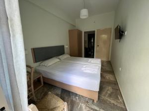 - une chambre avec un grand lit et des draps blancs dans l'établissement Neapolis Apartments, à Paleóchora