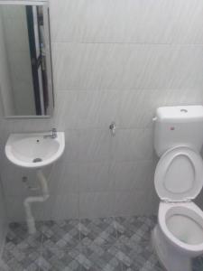 a bathroom with a toilet and a sink at Adilah Homestay B in Pasir Puteh