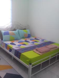 - un lit dans une chambre avec un cadre de lit dans l'établissement Adilah Homestay B, à Pasir Puteh
