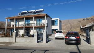 two cars parked in a parking lot in front of a building at Tsaghkunk Chef house in Sevan