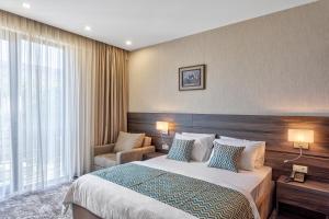 a hotel room with a bed and a chair at Vinum Hotel in Tbilisi City