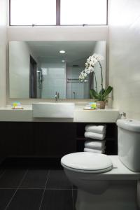 W łazience znajduje się umywalka, toaleta i lustro. w obiekcie Fahrenheit Suites Bukit Bintang, Kuala Lumpur w Kuala Lumpur