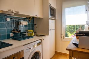 uma cozinha com uma máquina de lavar roupa e uma janela em Troia Beach and Nature - Apartment em Tróia