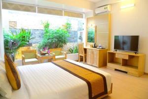a bedroom with a bed and a large window with a television at Ánh Dương Hotel Hải Phòng in An Khê