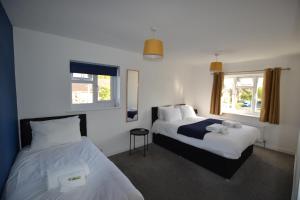 a hotel room with two beds and a window at Wisteria 2 bed House - STAYSEEKERS in Salisbury