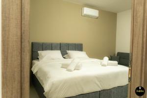 um quarto com uma grande cama branca com almofadas brancas em Pinolia Rooms em Quios