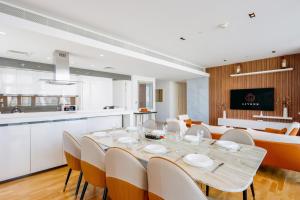 a dining room and kitchen with a table and chairs at Livbnb - Alluring 3BR+1 w/Sea & Ain Dubai View in Dubai