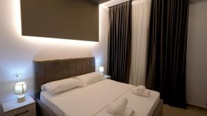 Perla e Dumrese, Bar-Restaurant-Hotel في Belsh: غرفة نوم عليها سرير وفوط