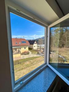 a window in a room with a view of a house at Ferienwohnung Viktring 4-5 Pers. in Klagenfurt