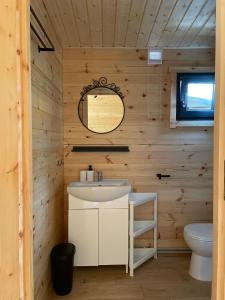 uma casa de banho com um lavatório e um WC em Toscana Camp em Pogorzelica