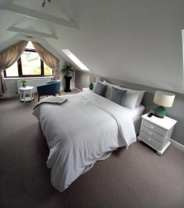 a bedroom with a large white bed and a window at Atlantic Shore B&B in Bantry