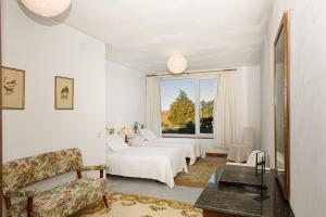 Habitación blanca con 2 camas y ventana en Hotel Rural Costa del Trigo en Segovia