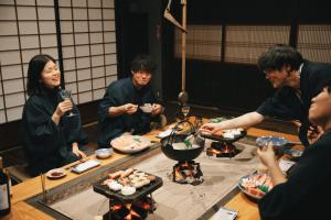 Un groupe de personnes autour d'une table qui mange des sushis dans l'établissement 一棟貸しの古民家 燕と土と, 