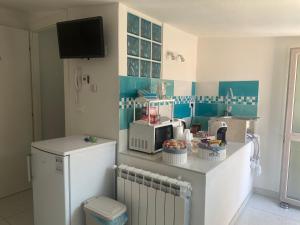a kitchen with a counter with a microwave and a refrigerator at LAGUNA BLU Camera CIELO con terrazza panoramica in comune in Chioggia