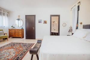1 dormitorio con 1 cama blanca grande y vestidor en ג'וליוס סוויטה, en Adamit