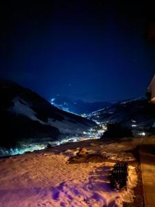 a night view of a snow covered mountain with a city at Lienbichl in Saalbach Hinterglemm