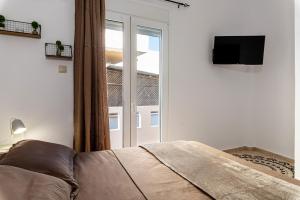 a bedroom with a bed and a sliding glass door at Appartamento Mare calmo-Myrtos in Myrtos