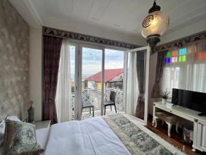a bedroom with a bed and a balcony with a television at Ersari Hotel in Istanbul