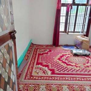 Habitación con alfombra roja y blanca en el suelo en POP Fareeda Homestay 