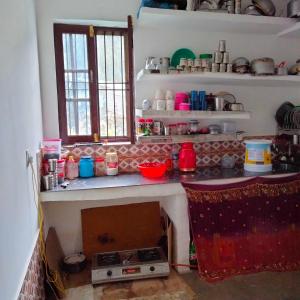 a kitchen with a counter with a stove in it at POP Fareeda Homestay 