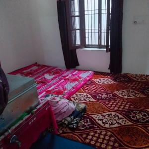 a room with a bed with a table and a suitcase at POP Fareeda Homestay 