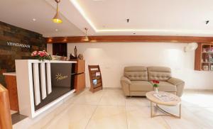 a living room with a couch and a television at Hotel Vrindavan in Wayanad