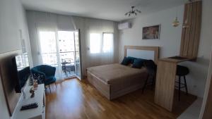 una piccola camera con letto e balcone di Apartmani Stari Aerodrom a Podgorica