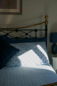 ein Bett mit einem schwarzen Rahmen und blauen Kissen in der Unterkunft Cwm Lodge, an idyllic retreat in the heart of Herefordshire! in Hereford