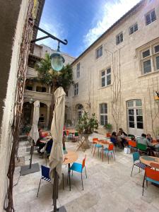 a courtyard with tables and chairs and a building at Mont-Ventoux, Provence, Appartement avec vue panoramique et piscine in Mollans-sur-Ouvèze