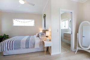 a white bedroom with a bed and a mirror at Old Salt Beach House in Marcus Beach +19 photos
