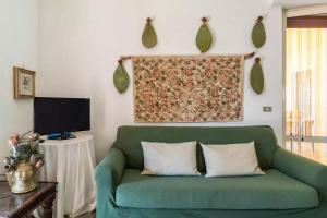 サンタ・マリア・デル・フォカッロにあるVilla Marina D'Orienteのリビングルーム(緑のソファ、テレビ付)