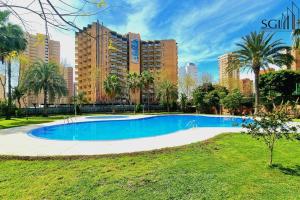 ベニドルムにあるMODERNO y ACOGEDOR- Torres D' Oboeの高層ビルが立ち並ぶ公園内のスイミングプール