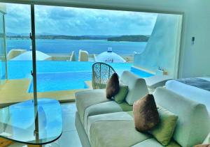 a living room with a couch and a view of the water at Yuki Suite Kourijima in Nakijin